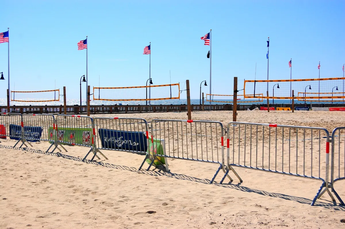 This lively beach scene captures volleyball nets set up on the sand, American flags, and people enjoying outdoor activities. The setting is bright, energetic, and quintessentially Myrtle Beach, highlighting both recreational options and scenic coastal beauty.