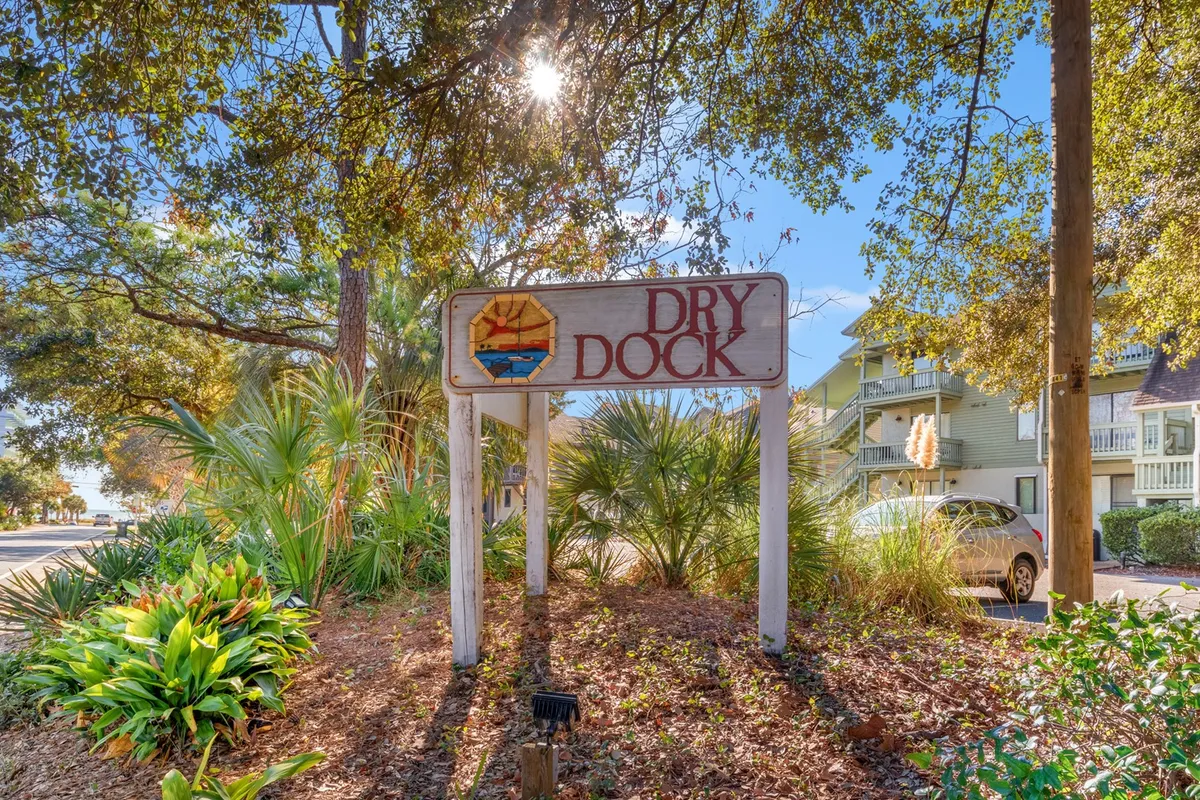This image shows inviting signage surrounded by landscaping and nearby buildings. The scene captures people walking and exploring the local area, offering a glimpse into the immediate environment guests can enjoy. The mood is sunny and welcoming, suggesting easy access to neighborhood highlights.